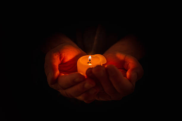 istock Hand holding burning candle in dark background. Selective focus,black background. Copy space. 2248661880