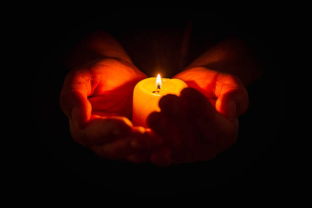 istock Hands holding burning candle in dark background. Selective focus,black background. Copy space. 2248661887