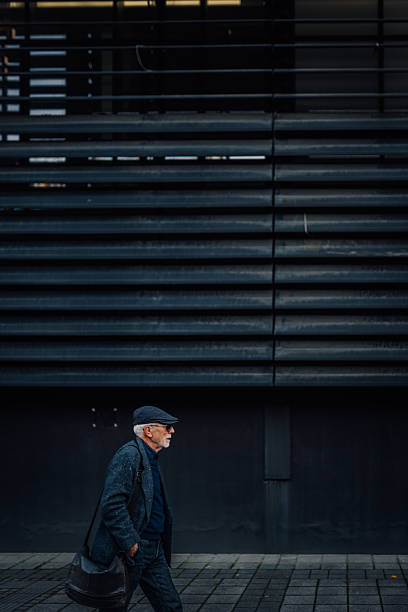 istock Senior man walking urban street in profile 2248663258
