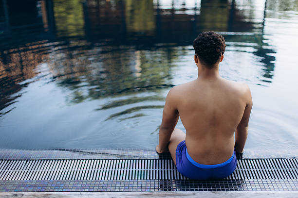 istock Swimmer relaxing after training at the poolside 2248663525
