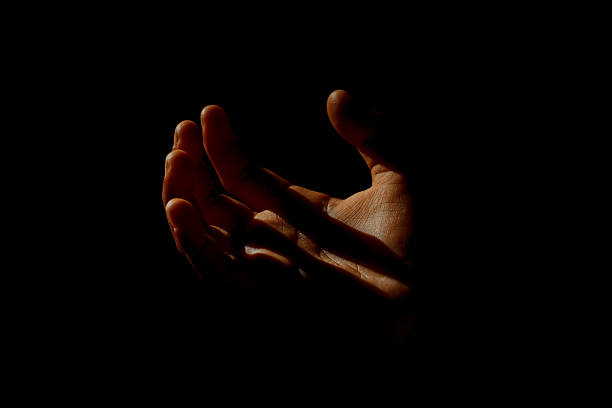 istock A human hand illuminated by sunlight amidst darkness. The high contrast between light and shadow creates a dramatic and artistic atmosphere. The concept of hope, the search for light, and life 2248665490