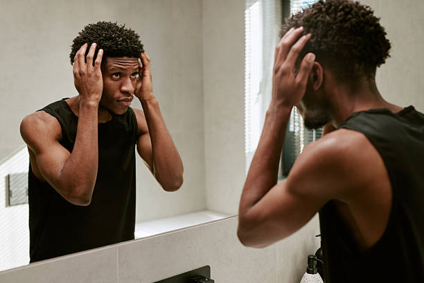 istock Young Black Man Grooming Hair in Bathroom Mirror during Morning Routine 2248667128