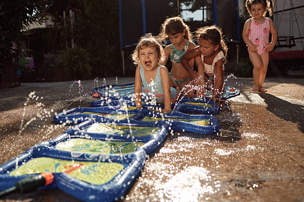 Children playing with sprinkler mat enjoying summer fun