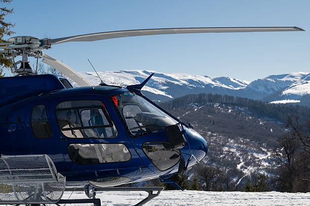 istock A blue helicopter awaits on a snowy mountain, ready for heli-skiing. Surrounded by pine trees and stunning alpine scenery under a clear blue sky, it captures the essence of winter adventure 2248668848