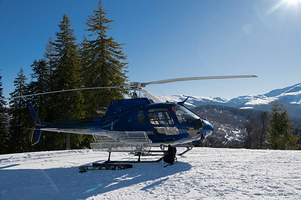 istock A blue helicopter awaits on a snowy mountain, ready for heli-skiing. Surrounded by pine trees and stunning alpine scenery under a clear blue sky, it captures the essence of winter adventure 2248668939