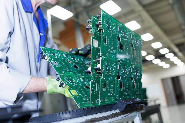 istock Worker handling assembled green circuit board panels at electronics factory 2248669904