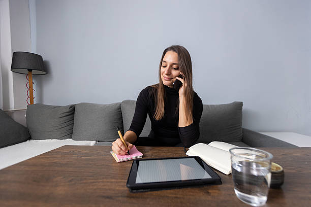 istock Woman working from home taking notes during phone call 2248670929