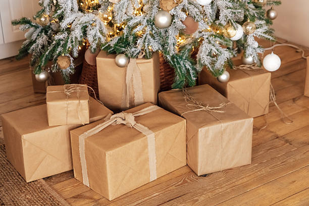 istock Wrapped presents sit under a decorated Christmas tree with warm lights in a cozy room 2248672637