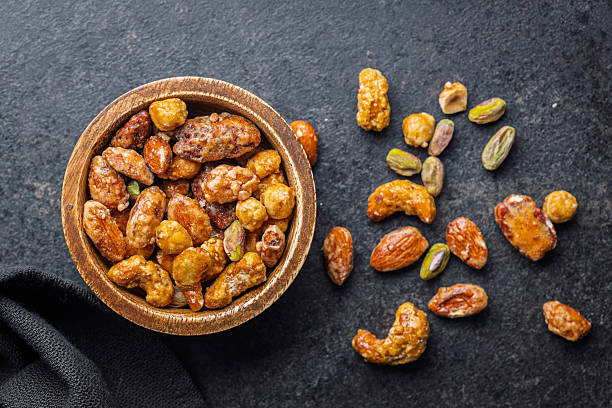 istock Nuts coated in sugar glaze in bowl on black table. 2248678170