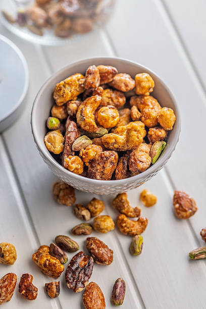 istock Nuts coated in sugar glaze in bowl  on white table. 2248678173