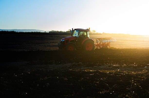 istock Tractor plowing field the land at sunset 2248678436