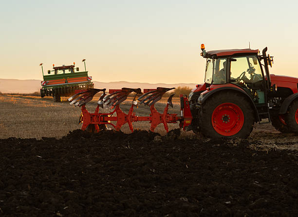 istock Tractor plowing field the land at sunset 2248678456
