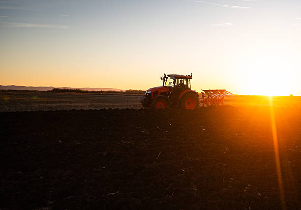 istock Tractor plowing field the land at sunset 2248678459