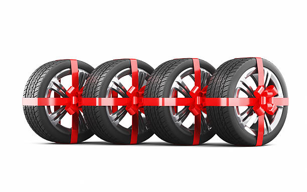 istock New Car Tires with Alloy Wheel Gift Wrapped in Red Ribbon, Object + Shadow Path 2248679027