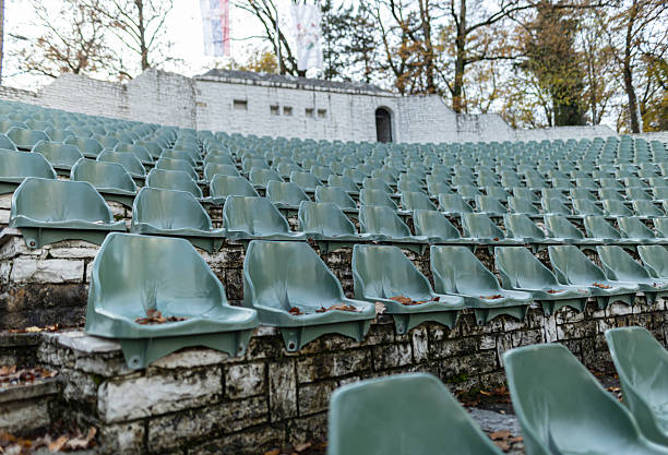 Bright closed parasol between the empty rows of seats of an outdoor theater