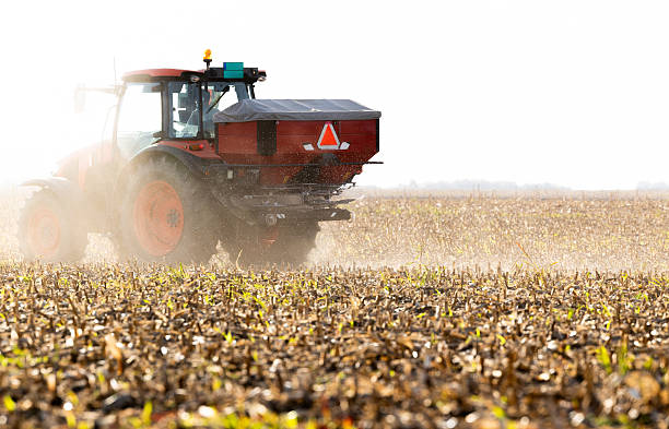 istock Tractor spreading artificial fertilizers in field 2248680185