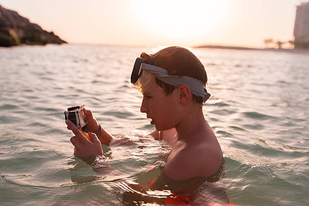 istock Boy enjoys snorkeling while capturing underwater moments during sunset at a tropical beach 2248680904