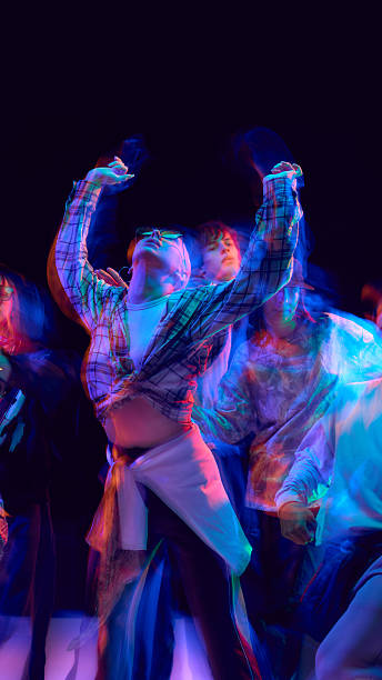 istock Group of dancers illuminated by neon motion blur light 2248681228