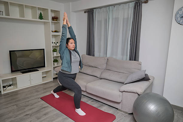istock Woman doing yoga lunge pose at home 2248682650