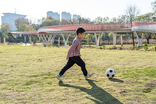 Child playing football on a soccer field