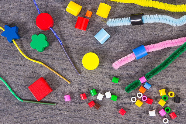 Thread, creative sticks and colorful beads used to making bracelets, learn counting and arranging various shapes. Development of kids motor skills, creativity and logical thinking