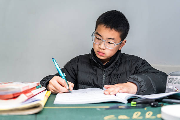 istock A young boy wearing glasses is studying at a desk 2248684420
