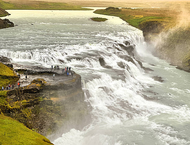 Gulfoss waterfall, Iceland - 31 August 2024: Scenic landscape view of people visiting the Gullfoss waterfall in southwestern Iceland on a wet day