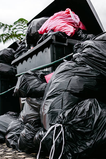 istock Overflowing black garbage bins filled with trash bags 2248684674