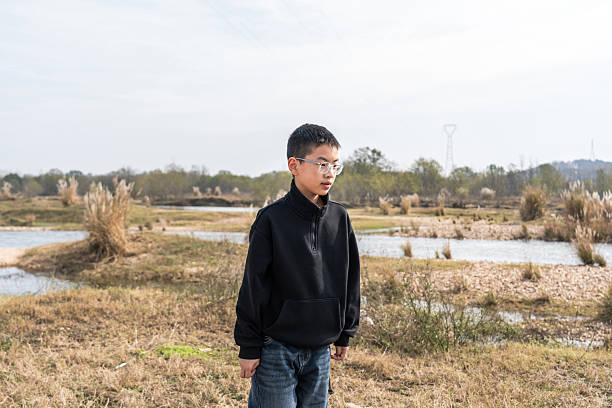 istock Young boy standing in an open area with water bodies 2248684858