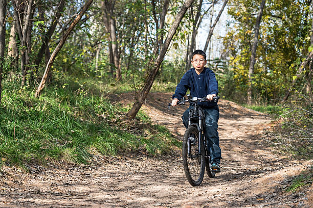 istock A boy riding a bicycle on a forest trail 2248685410