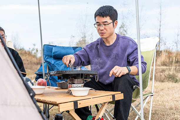 istock Man cooking outdoors in a camping setting enjoying leisure time 2248685818