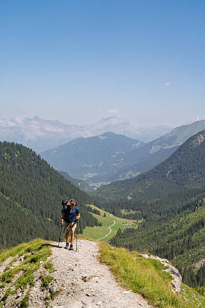 istock Hiker walking down steep alpine trail overlooking valley, French Alps 2248690626