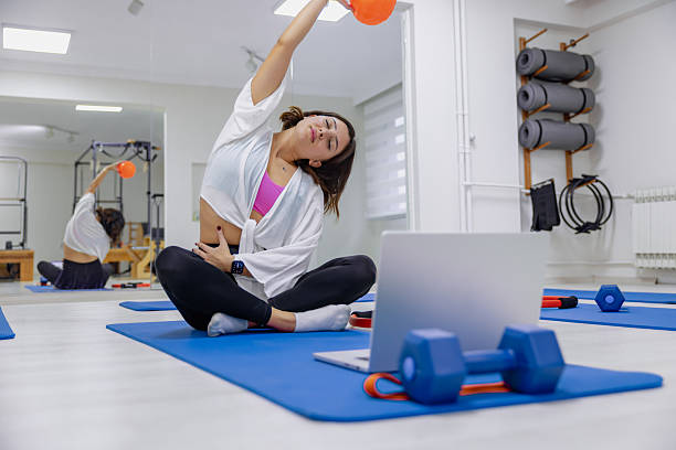 Young Pilates Instructor Gives Online Exercise Classes with a Ball in the Studio