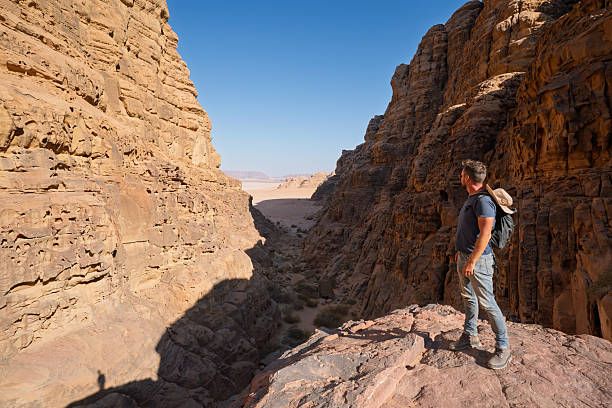 istock Hiker standing on ledge viewing narrow sandstone canyon in Wadi Rum, Jordan 2248691025