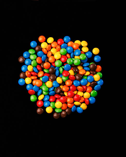 Multicolored dragee with chocolate egg, Easter, candy background, sweets