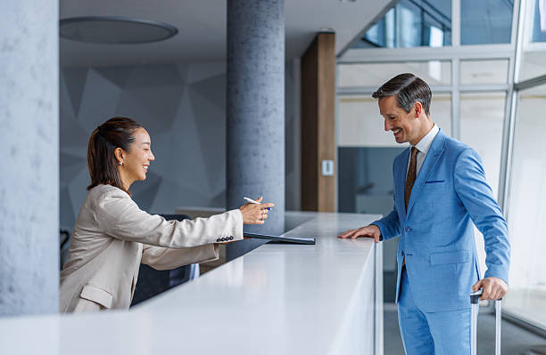 istock Smiling receptionist helping businessman checking in at hotel 2248692899