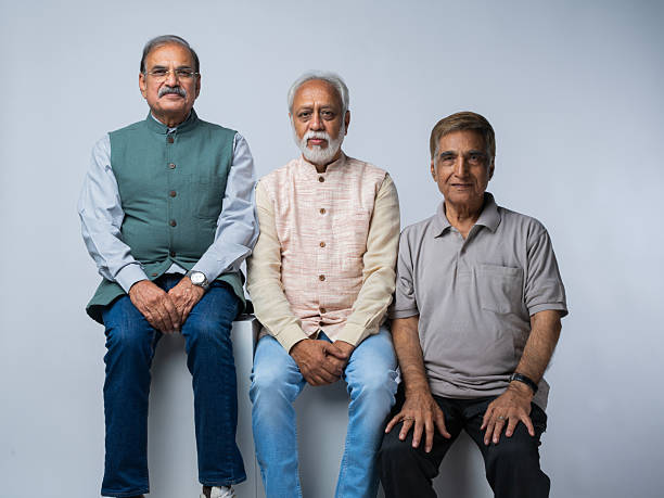 istock Senior friends sitting on blocks against white background 2248694069