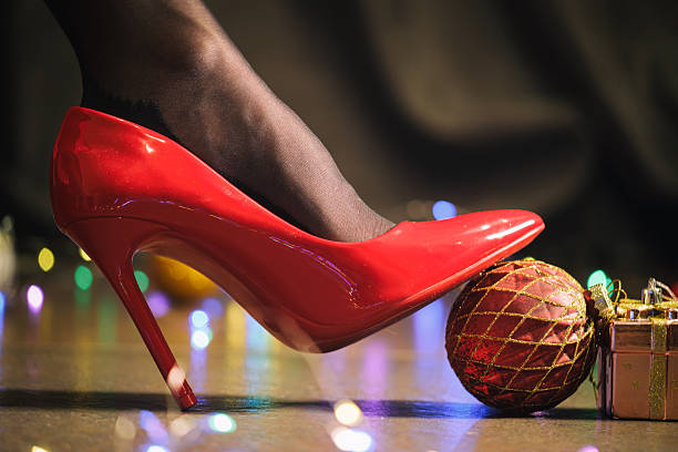 A pair of elegant red high heels rests on a modern couch, highlighting their intricate design, as a decorative plant in the background adds charm to the inviting atmosphere