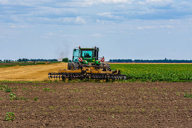 istock Tractor plowing field with the harrow. Agricultural concept 2248695239