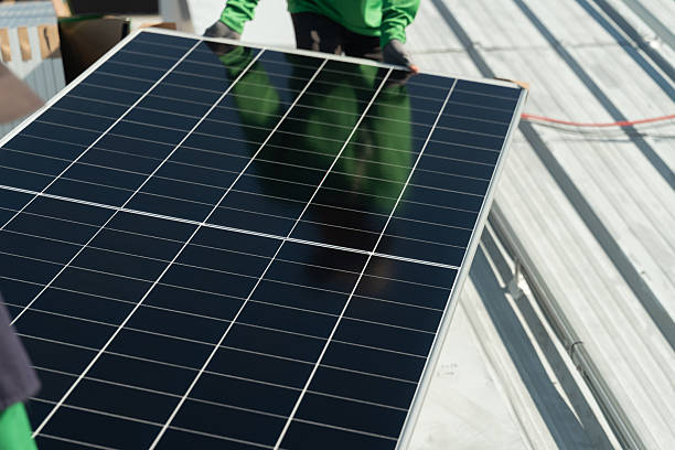 istock Workers install a solar panel on a roof during daylight in a green energy initiative 2248702036
