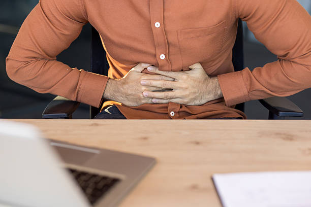 istock Man suffering from stomach pain at office desk 2248703566