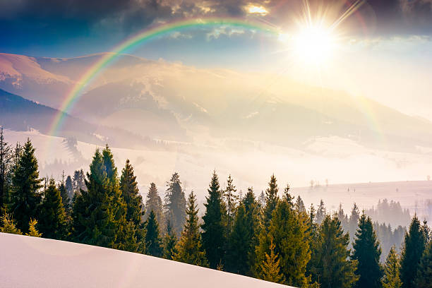 istock winter landscape at sunset. fir trees on snow covered hill in evening light 2248704302