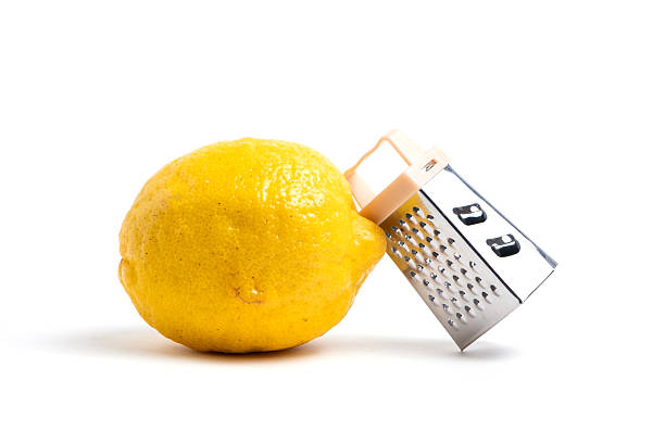 Lemon and grater on a white background.