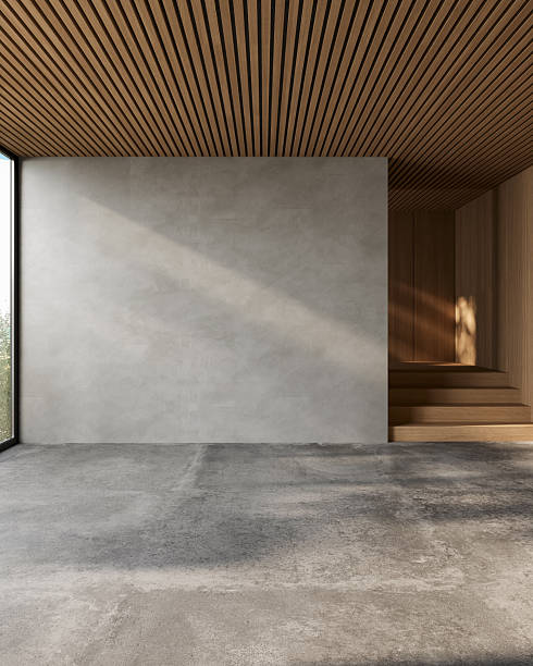 istock Minimalist interior with textured empty wall, concrete floor and warm wooden finishes, sunlight softly hitting the space, perfect for mockups or background use, 3d render. 2248706640