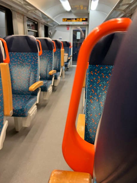 istock Empty suburban train carriage with blue patterned seats and orange handles, shallow depth of field, evening commute scene. Blurred Train chairs. 2248707392