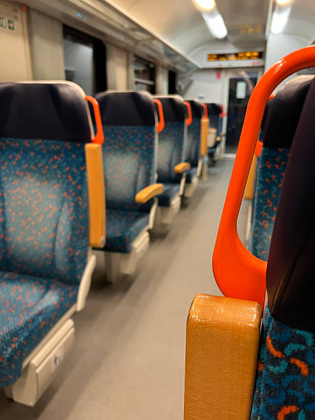 istock Empty suburban train carriage with blue patterned seats and orange handles, shallow depth of field, evening commute scene. Blurred Train chairs. 2248707394