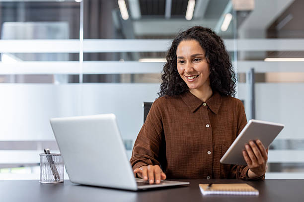istock Young businesswoman multitasking and smiling while working in office 2248707484