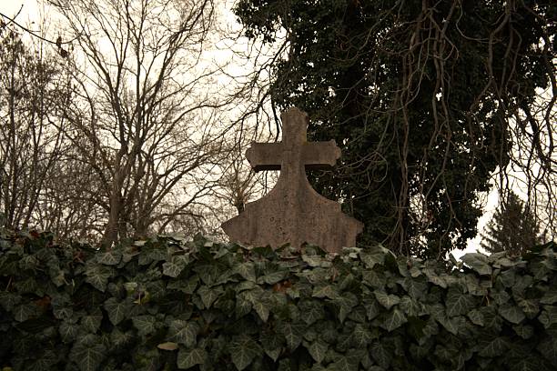 Old copper angel statue and a stone cross in a cemetery