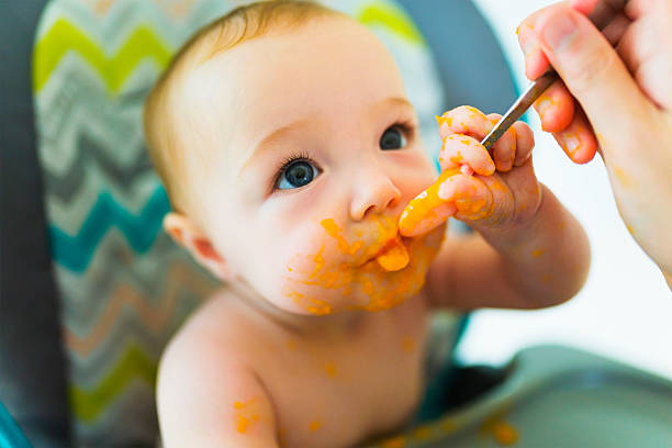 istock Mother feeding her happy little cute daughter 2248708198
