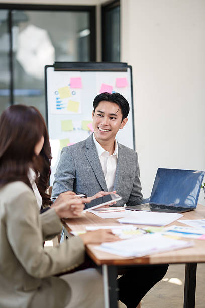 Businessman is standing and presenting his work in a conference room.